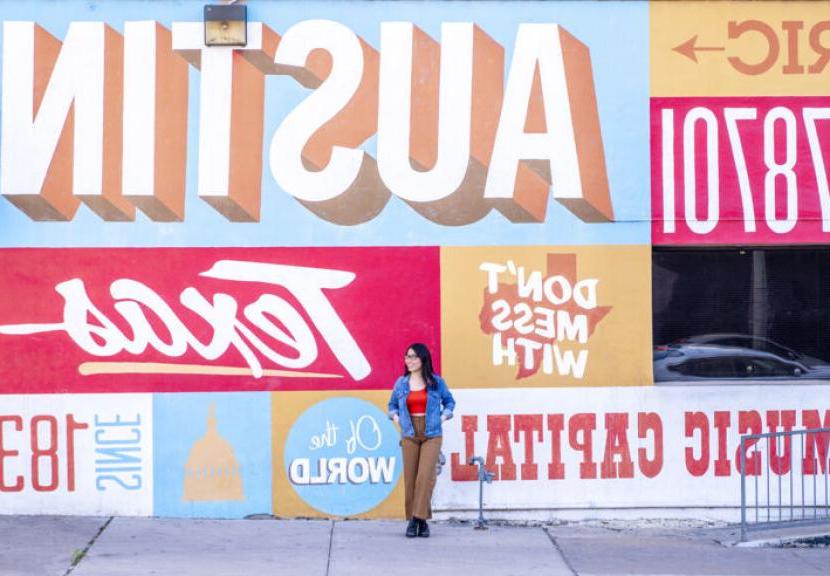 一个圣. Edward's student in front of a mural in downtown Austin, Texas